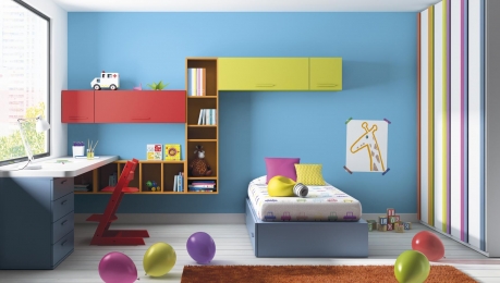 dormitori infantil amb llit niu, taula estudio llibreries i original armari amb grans tiradors creant l'efecte 'pijama'